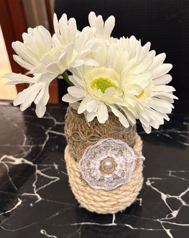 PEQUEÑO JARRON DE VIDRIO DECORADO CON YUTE Y FLORES ARTIFICIALES