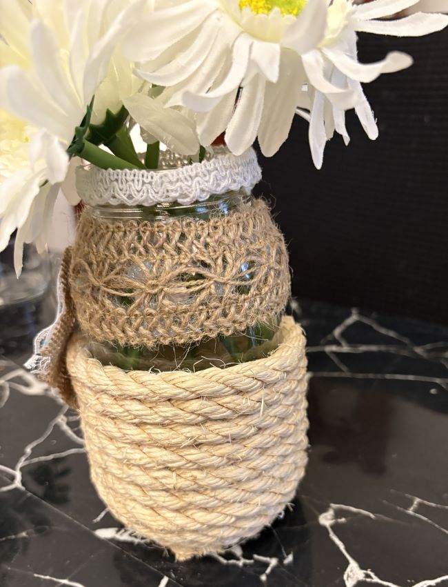 PEQUEÑO JARRON DE VIDRIO DECORADO CON YUTE Y FLORES ARTIFICIALES