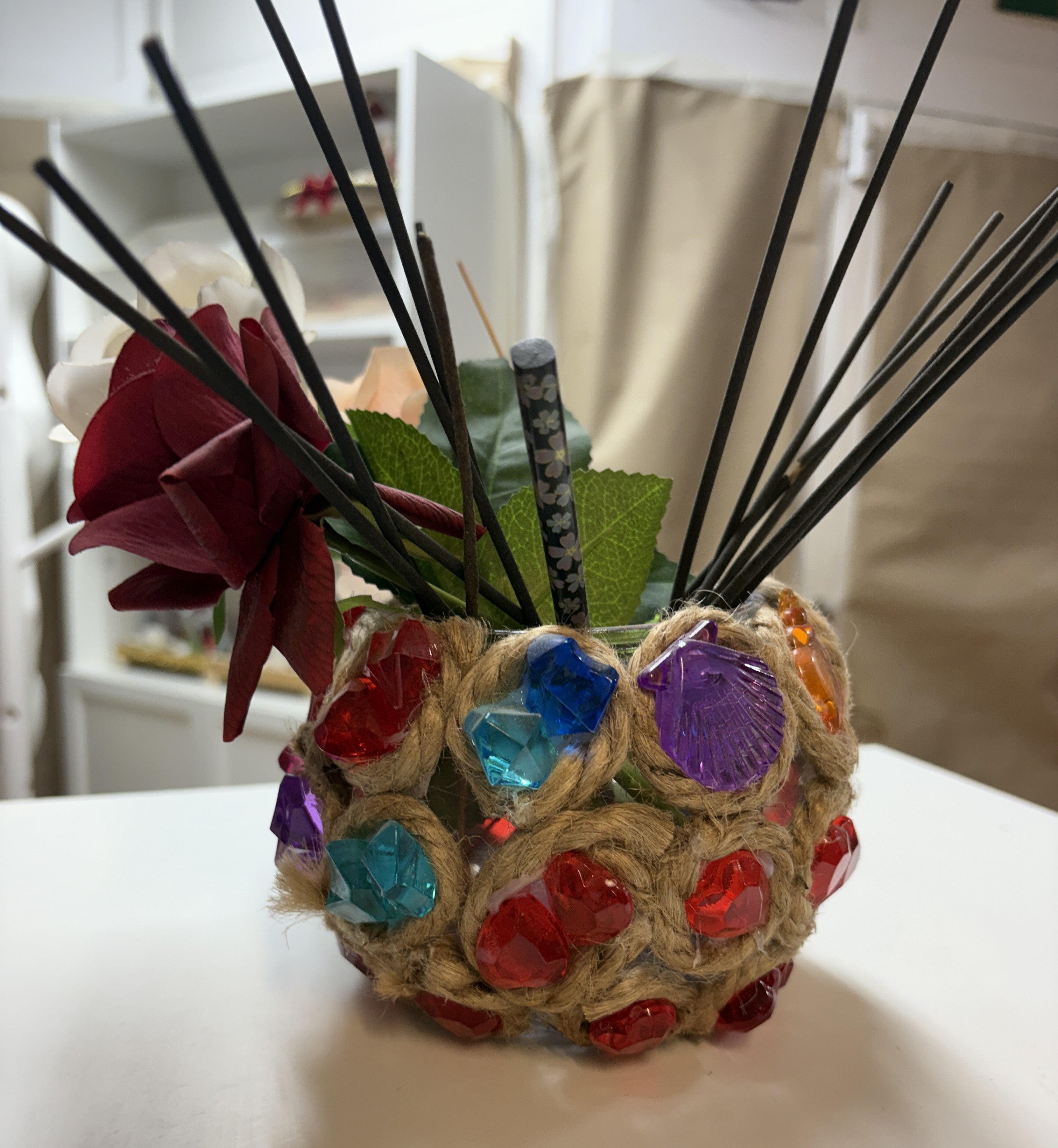 JARRON DE VIDRIO CON YUTE Y DECORADO CON PIEZAS DE COLORES Y FLOR ARTIFICIAL