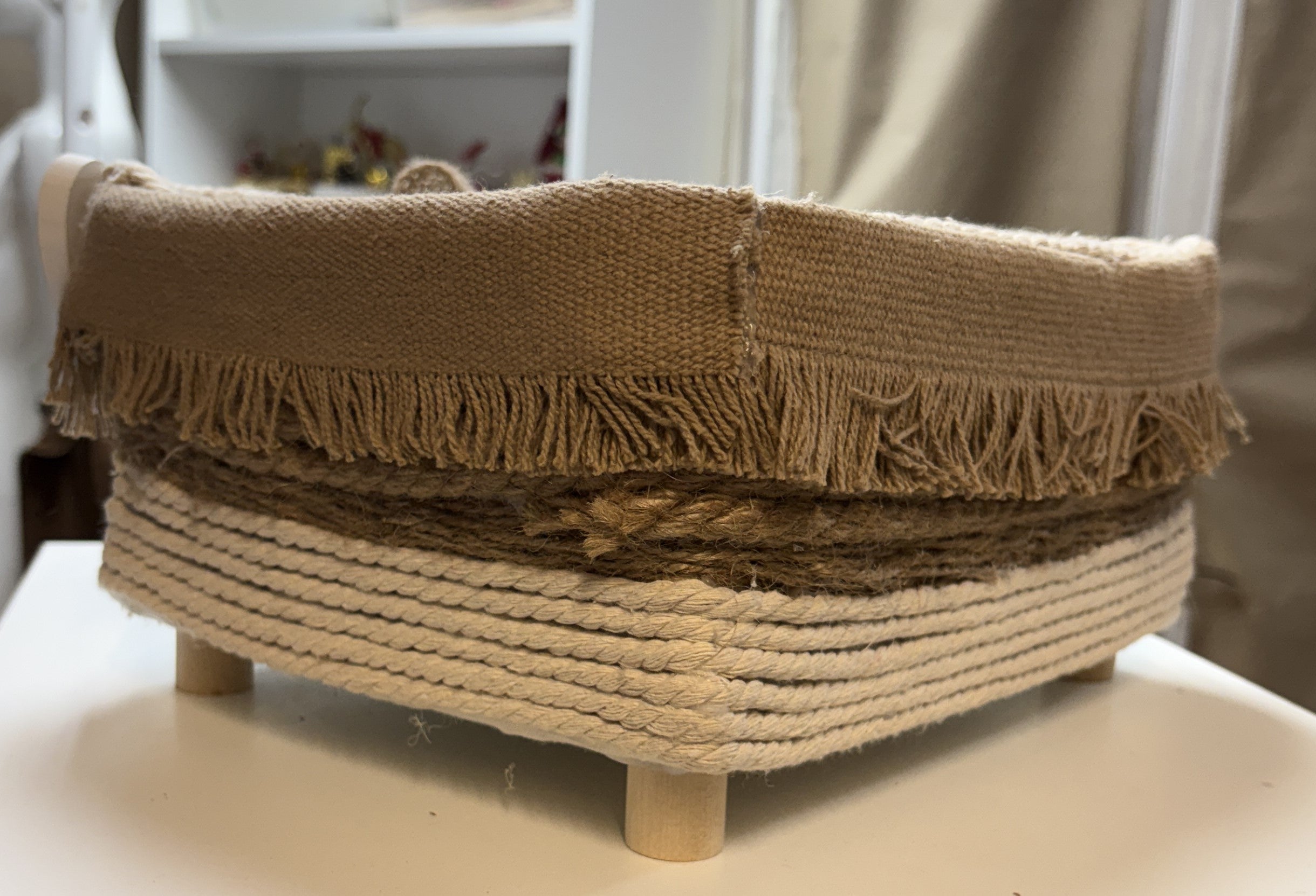 CESTA MARRON DE TELA CON FLECOS CON ALGON TRENZADO Y PATAS DE MADERAS