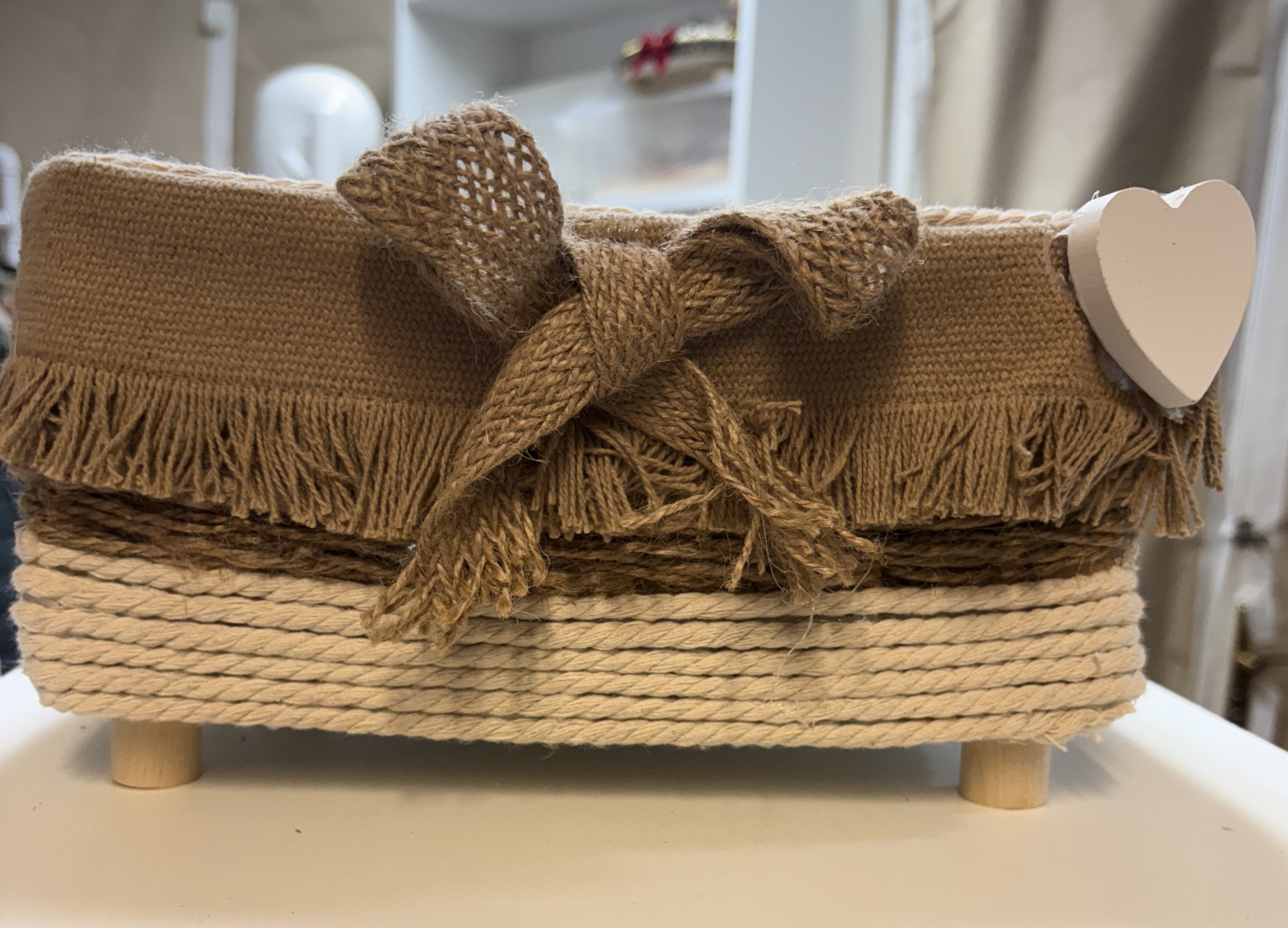 CESTA MARRON DE TELA CON FLECOS CON ALGON TRENZADO Y PATAS DE MADERAS
